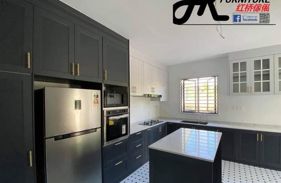 A navy-and-white shaker aluminium kitchen with brass bar handles, a stainless fridge, a built-in oven tower, a white stone island and patterned floor tiles.